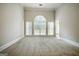 Bright, carpeted living room featuring a large arched window and decorative trim at 250 Kari Glen Dr, Fayetteville, GA 30215