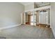 Open living room featuring neutral carpet, decorative columns, and access to hardwood foyer and front door at 250 Kari Glen Dr, Fayetteville, GA 30215