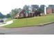 Well-maintained lawn of brick home shows landscaped curb appeal on a corner lot in a neighborhood at 4955 Highland Lakes Dr, South Fulton, GA 30349