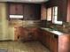 Interior kitchen with worn cabinets, laminate counters, backsplash, and tile floor at 6154 Green Acres Sw Dr, Covington, GA 30014