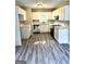 Bright kitchen featuring white cabinets, stainless steel appliances, and modern gray flooring at 2204 Liberty Sw Ln, Conyers, GA 30094