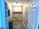 Functional laundry room with overhead storage and hookups, complemented by gray flooring at 2204 Liberty Sw Ln, Conyers, GA 30094