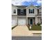 Charming townhome featuring brick facade, white garage doors, and manicured lawn at 8714 Lakeview Commons # 48, Jonesboro, GA 30238
