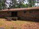 Brick home back exterior featuring a patio, windows, and ample yard space at 7225 Pineneedle Sw Dr, Covington, GA 30014