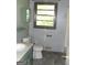 Modest bathroom with a single sink vanity, toilet, and a window providing natural light at 9176 Carr Sw Cir, Covington, GA 30014