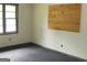 Bedroom with a window and dark gray carpet, and a wooden panel on the wall at 9176 Carr Sw Cir, Covington, GA 30014