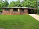 Cozy brick home featuring a lush green lawn and a convenient covered carport at 9176 Carr Sw Cir, Covington, GA 30014