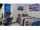 This bedroom features gray walls, matching blue and gold colored bedding, and a desk with a computer monitor on it at 1401 Aberdeen Ct, Mcdonough, GA 30253