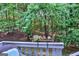View from the patio showing the tree-filled backyard with foliage and outdoor decoration at 2566 Summit Cove Dr, Duluth, GA 30097