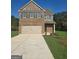 Two-story brick house with a two-car garage and driveway, complemented by a well-maintained lawn and landscaping at 5705 Laney Dr, Rex, GA 30273