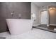 Modern bathroom with soaking tub featuring gray tile, mosaic tile floor, and a chrome handheld shower head at 294 Clearview Ct, Villa Rica, GA 30180