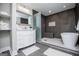 Modern bathroom with shower featuring gray tile, a glass partition, rain shower head, and a white soaking tub at 294 Clearview Ct, Villa Rica, GA 30180