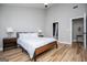 Bright bedroom features wood-look floors, a ceiling fan, and a view to the ensuite bath at 294 Clearview Ct, Villa Rica, GA 30180