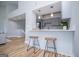 Bright kitchen boasts gray cabinets, stainless appliances, pendant lighting and eat-in bar with wood stools at 294 Clearview Ct, Villa Rica, GA 30180