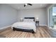 Bright main bedroom featuring a ceiling fan, wood floors, two side tables with lamps, and a queen bed at 294 Clearview Ct, Villa Rica, GA 30180