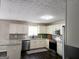 Kitchen features white cabinetry, stainless appliances and dark floors at 247 Water Oak Ln, Jonesboro, GA 30238