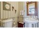 Charming powder room with decorative wallpaper, pedestal sink, and ornate mirror adding classic elegance at 3644 Graycliff Rd, Snellville, GA 30039