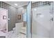 Bathroom featuring a glass-enclosed shower, tiled walls, and a built-in seat for comfort and convenience at 3644 Graycliff Rd, Snellville, GA 30039