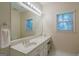 Well-lit bathroom features a large mirror, single vanity, window for natural light, and tile flooring at 3644 Graycliff Rd, Snellville, GA 30039
