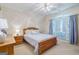 Bright bedroom featuring a wooden bed frame, blue accents, and a large arched window for ample natural light at 3644 Graycliff Rd, Snellville, GA 30039