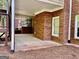Covered back patio area with brick accents, offering a cozy outdoor space for relaxation and entertainment at 6680 Bentley Trl, Cumming, GA 30040