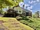 Spacious backyard featuring lush landscaping and a brick home with a wooden deck and screened in porch at 6680 Bentley Trl, Cumming, GA 30040