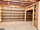 Unfinished basement with exposed ceiling and walls, featuring wooden shelving units at 6680 Bentley Trl, Cumming, GA 30040