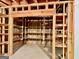 Unfinished basement area with exposed wooden framework and shelving units built against concrete walls at 6680 Bentley Trl, Cumming, GA 30040