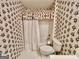 Quaint bathroom featuring floral wallpaper, a toilet, and a shower with a decorative curtain at 6680 Bentley Trl, Cumming, GA 30040