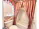 Charming bathroom with a red and white patterned shower curtain and matching wallpaper at 6680 Bentley Trl, Cumming, GA 30040