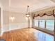 Formal dining room features hardwood floors, detailed trim, and large windows at 6680 Bentley Trl, Cumming, GA 30040