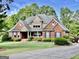Charming brick home with a well-kept lawn and beautiful landscaping, creating a welcoming curb appeal at 6680 Bentley Trl, Cumming, GA 30040
