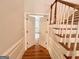 Welcoming foyer with hardwood floors and staircase, leading to a bright room through double doors at 6680 Bentley Trl, Cumming, GA 30040