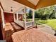 Charming front porch with brick flooring, white railings, and picturesque views of the landscaped yard at 6680 Bentley Trl, Cumming, GA 30040