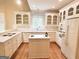 Bright kitchen featuring white cabinetry, hardwood floors, and a kitchen island at 6680 Bentley Trl, Cumming, GA 30040