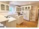 A well-lit kitchen with wooden floors, white cabinets, and stainless steel appliances at 6680 Bentley Trl, Cumming, GA 30040