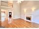 Spacious living room with hardwood floors, a fireplace, and access to the home's entry at 6680 Bentley Trl, Cumming, GA 30040