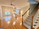 Open-concept living space features hardwood floors, a staircase, and a view into the kitchen at 6680 Bentley Trl, Cumming, GA 30040