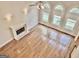 Bright living room featuring a fireplace, hardwood floors, and large windows at 6680 Bentley Trl, Cumming, GA 30040