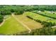 An aerial view of the farm land, fencing, and surrounding landscape at 1233 Butler Bridge Rd, Mcdonough, GA 30252