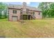 View of the backyard of a brick home with a deck, a garage, and a spacious lawn at 1233 Butler Bridge Rd, Mcdonough, GA 30252