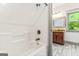 Well-lit bathroom with a white shower/tub combination and a vanity with granite counters in the background at 1233 Butler Bridge Rd, Mcdonough, GA 30252