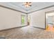 Large bedroom with a tray ceiling, carpet flooring, windows, and an en suite bathroom entrance at 1233 Butler Bridge Rd, Mcdonough, GA 30252