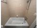 Standard bathtub with tiled walls and shower fixture at 1329 Springwood Nw Dr, Conyers, GA 30012