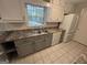 Galley kitchen with tile floors, gray cabinets, and updated appliances at 1329 Springwood Nw Dr, Conyers, GA 30012