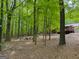 View of a backyard featuring lush green trees and a house with a wood deck at 712 Honeysuckle Ln, Temple, GA 30179