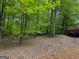 Wooded backyard featuring mature trees, leaves, and a deck provides a private and natural setting at 712 Honeysuckle Ln, Temple, GA 30179