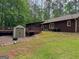 A backyard featuring a shed, wood deck, and a house with neutral-colored walls at 712 Honeysuckle Ln, Temple, GA 30179