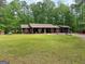 Inviting single story house with a well-maintained lawn and mature trees providing ample shade at 712 Honeysuckle Ln, Temple, GA 30179