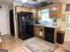Bright kitchen featuring wood cabinets, black appliances, and a window with a blue checkered curtain at 712 Honeysuckle Ln, Temple, GA 30179